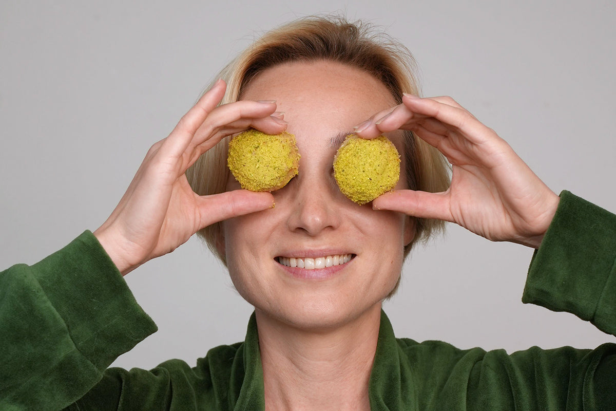 Woman playfully places Sogarina Baklava on her eyes, seeing the world through sweeter lenses.